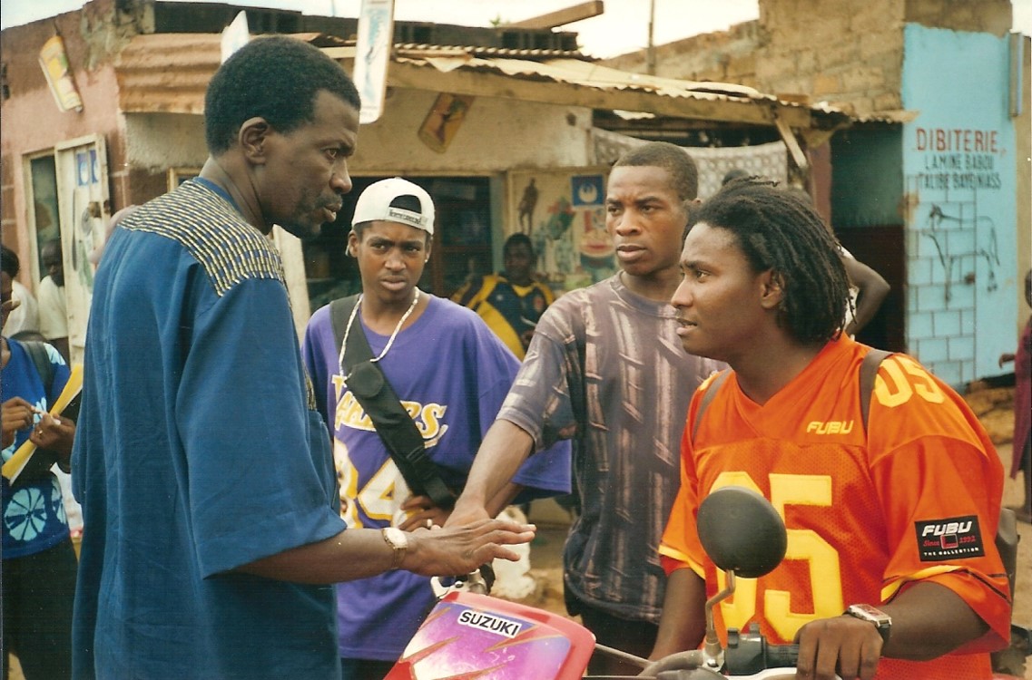 Celebrated Malian filmmaker Cheick Oumar Sissoko (left) directed rapper/actor Didier Awadi (in orange)